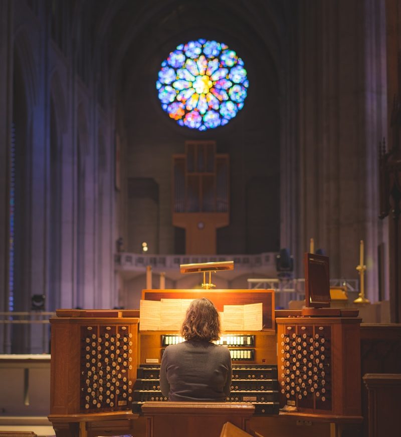person sitting in front of church organ