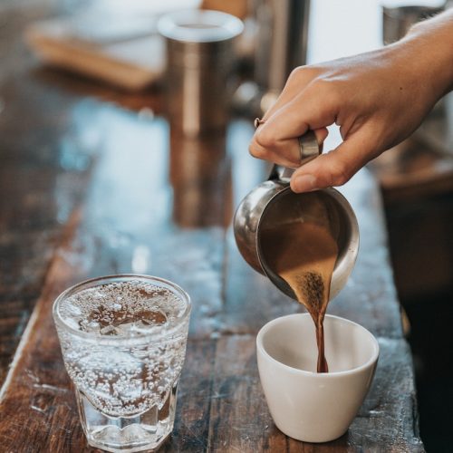person pouring coffee in mug